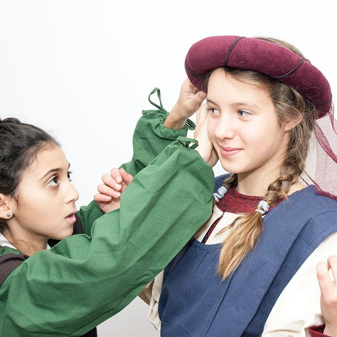 Zwei Mädchen beim Ankleiden an der Aktiv-Station &quot;Mode im Mittelalter&quot; ein