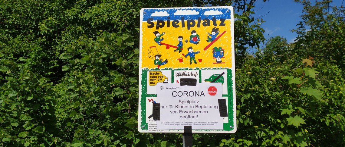 Spielplatzschild mit Hinweis: Corona Spielplatz nur für Kinder in Begleitung von Erwachsenen geöffnet