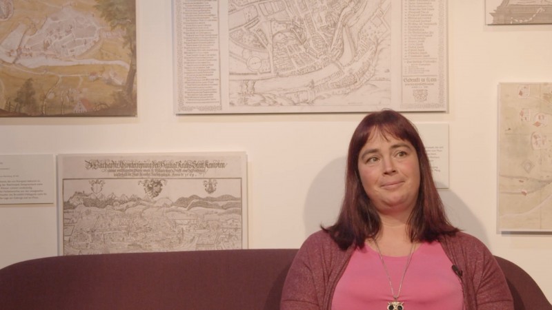 Daniela Leitermann-Übelhör vor Wand mit historischen Straßenkarten