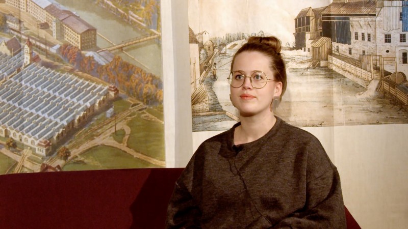Julia Obermaier vor historischen Gemäden der Stadt Kempten