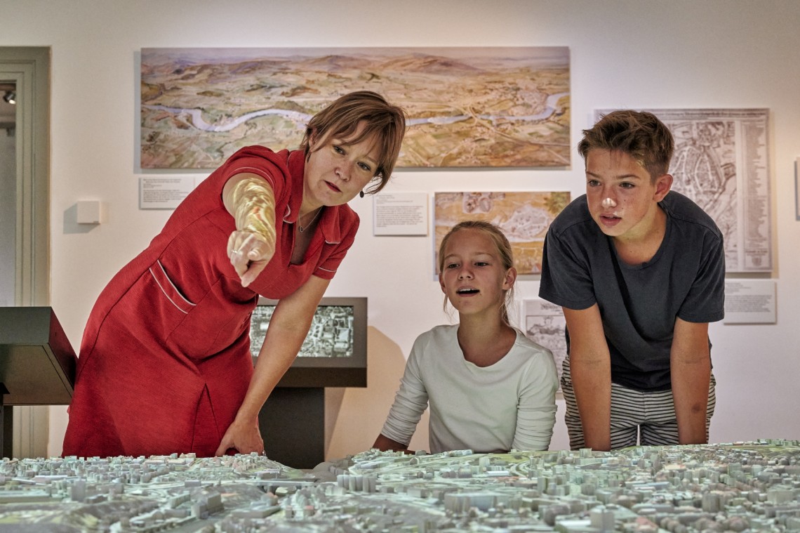 Museumsleiterin Christine Müller Horn mit zwei Kindern an 3D-Stadtmodell