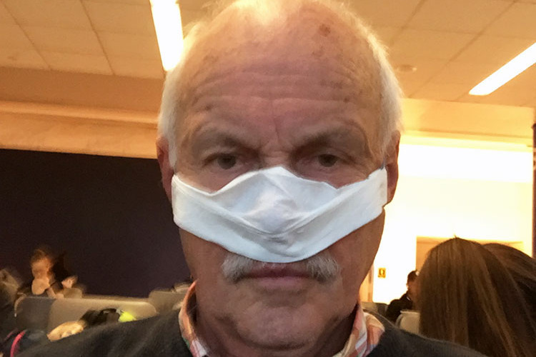 Älterer Mann mit viel zu kleiner selbst hergestellter Maske, die gerade die Nase bedeckt.