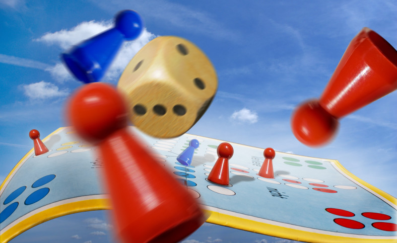 Spielfiguren fliegen &uuml;ber ein Spielbrett