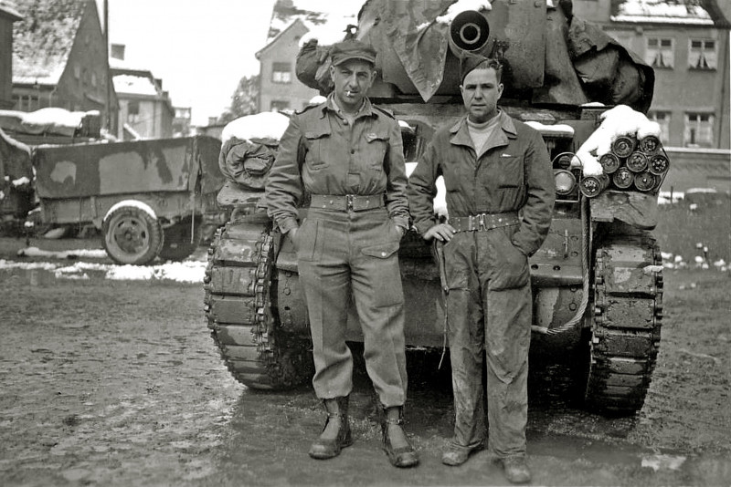 schwarz-weiß Foto von zwei Soldaten, die vor einem Panzer stehen
