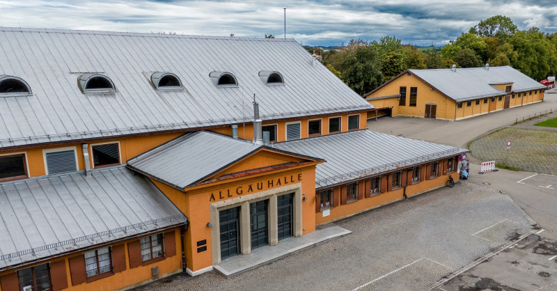 das Gebäude der Allgäuhalle in Kempten, ein orangfarbener Flachbau, der als KZ-Außenlager diente