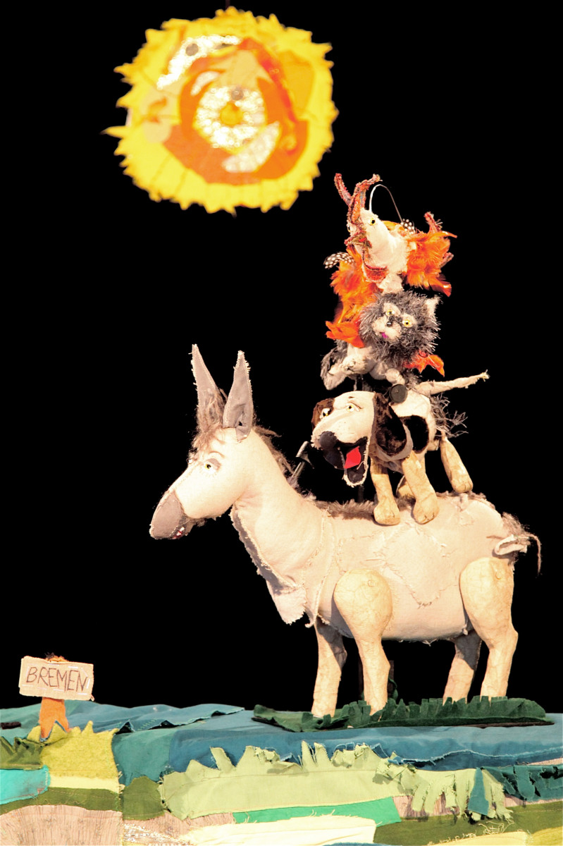 Zwei schwarz gekleidete Puppenspielerinnen mit Puppentheater