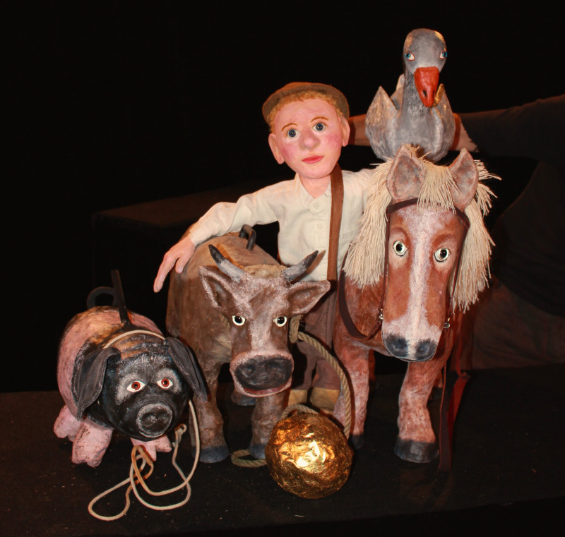 Zwei schwarz gekleidete Puppenspielerinnen mit Puppentheater