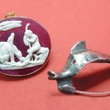 Amulett und Fibel (Gewandspange) in Delphinform