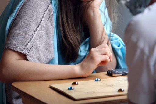 M&auml;dchen spielt r&ouml;misches M&uuml;hlespiel