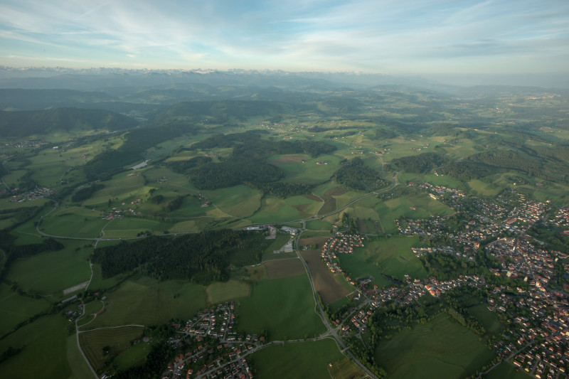 Blick in eine Berglanschaft, im Vordergrund ein Haus, das aus alten Fensterrahmen gebaut ist